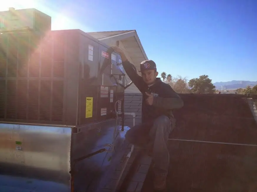 HVAC technician performing AC Tune-Up on a rooftop unit in New Milford